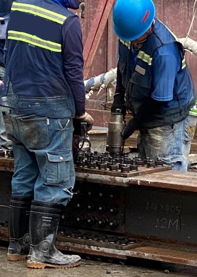 Structural bolting crew aligning and installing beam splices meeting AISC-RCSC specifications