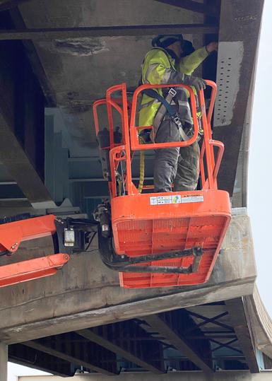 Quality Control Inspector reviewing structural steel connections during AISC certification process